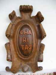 Escudo Charitas tallado en madera